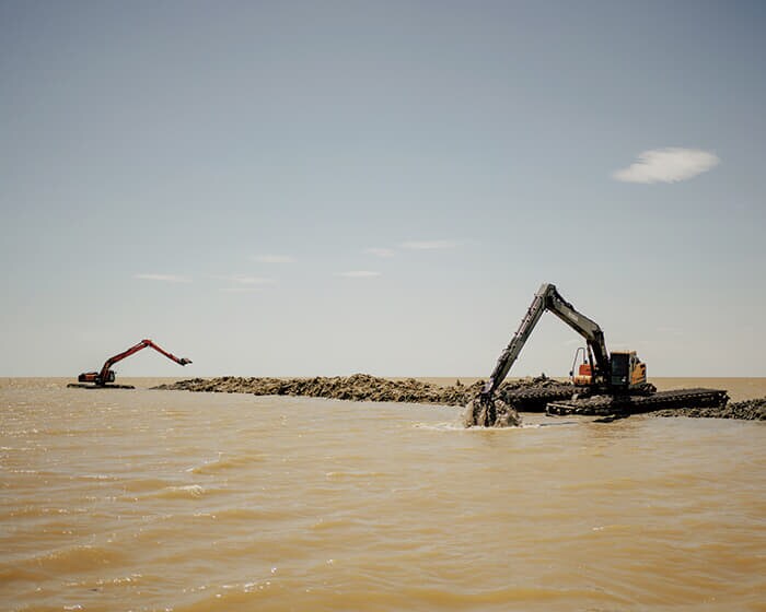 ダンバの河口付近を掘削する重機。水位が低すぎて魚が産卵のために川を遡上できない