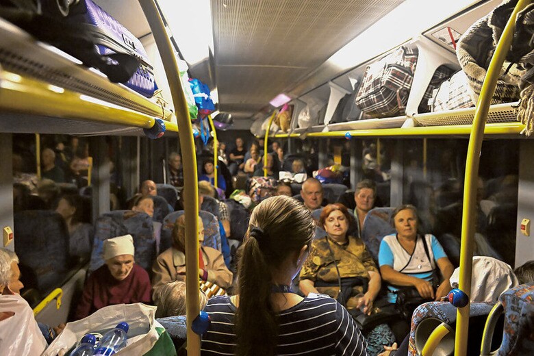 ポクロフスク中心部から出るドニプロ行きのバス内でボランティアから今後の説明を受ける人々（9月12日）　PHOTOGRAPHS BY KOSHIRO KOMINE