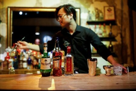 　若者の間でウイスキーやコニャックへの関心が高まる中国で、世界の大手飲料メーカーは市場拡大を狙っている。その前に立ちはだかるのが、中国を代表する高級酒「白酒」を生産する企業との競争だ。写真は、白酒をベースにしたカクテルを作るバーテンダー。２０１７年６月、北京で撮影（２０２４年　ロイター/Thomas Peter）