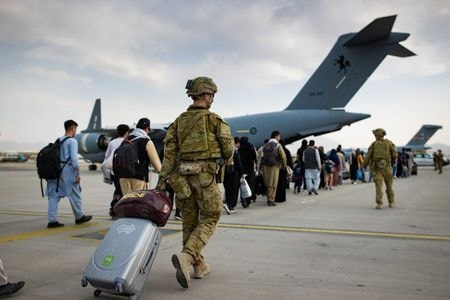 ８月２７日、オーストラリアのダットン国防相は、アフガニスタンの首都カブールの空港周辺で起きた自爆攻撃を巡り、豪軍関係者全員が爆発前にアフガンを離れており、死亡した豪兵はいないと明らかにした。写真はカブールの空港で２２日、豪軍機で出国するアフガン市民を案内する豪軍兵ら。提供写真（２０２１年　ロイター/ SGT Glen McCarthy/ Australia\'s Department of Defence）
