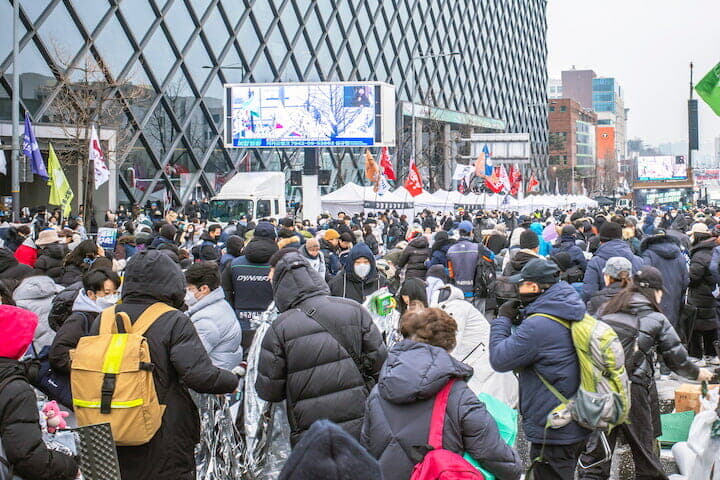着座用発泡スチロールやマットを持参する集会参加者たち