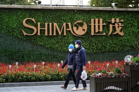 　１１月２日、香港に上場している中国の不動産会社少なくとも１４社の監査法人が今年に入って監査役を外れたことが、証券取引所に提出された資料で明らかになった。写真は世茂集団のロゴ前を歩く人々。上海市で２０２２年１月撮影（２０２２年　ロイター/Aly Song）