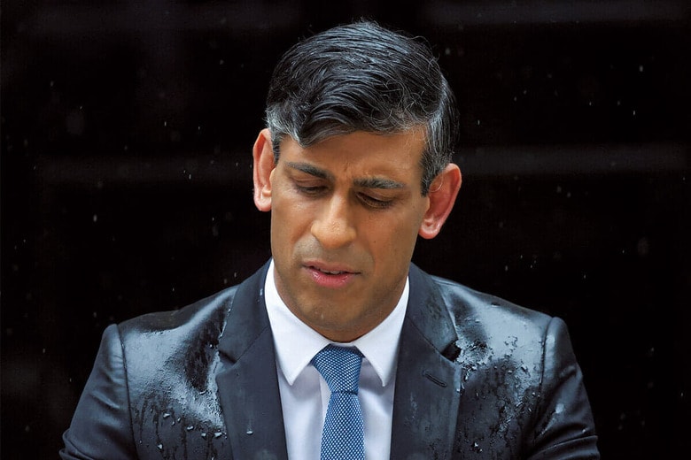 雨に打たれながら、議会の解散と総選挙の実施を発表するスナク　TOBY MELVILLEｰREUTERS