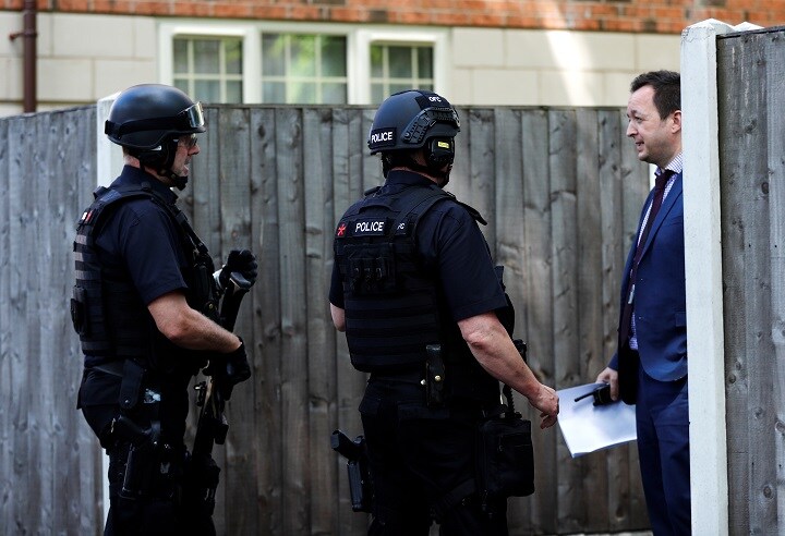 自爆テロと関連する男を逮捕した家の近くに立つ武装警官と私服警官（英マンチェスター、5月23日）　Stefan Wermuth-REUTERS