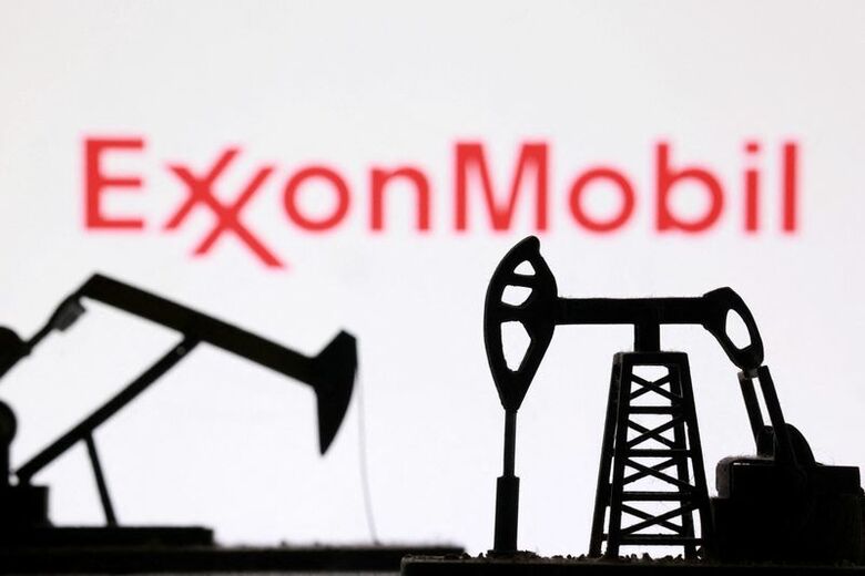 写真は米石油大手エクソンモービルのロゴと採掘のイメージ。3月2日に撮影。 REUTERS/Dado Ruvic