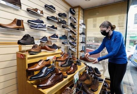 英国立統計局（ＯＮＳ）が２１日発表した４月の小売売上高は前月比９．２％増加した。写真は、開店準備をする靴店の従業員。北アイルランド・エニスキレンで2021年4月29日に撮影。（2021年　ロイター／Lorraine O\'Sullivan）