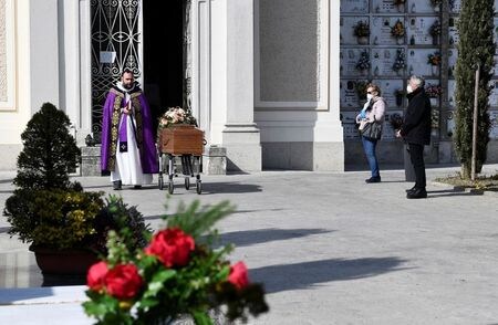 　イタリアでは２８日、新型コロナウイルス感染症による死者が１万人を突破した。世界全体では３万人を超えた。写真はマスクをして葬儀に参列する人たち。ロンバルディア州セリアテで撮影。（２０２０年　ロイター/Flavio Lo Scalzo）