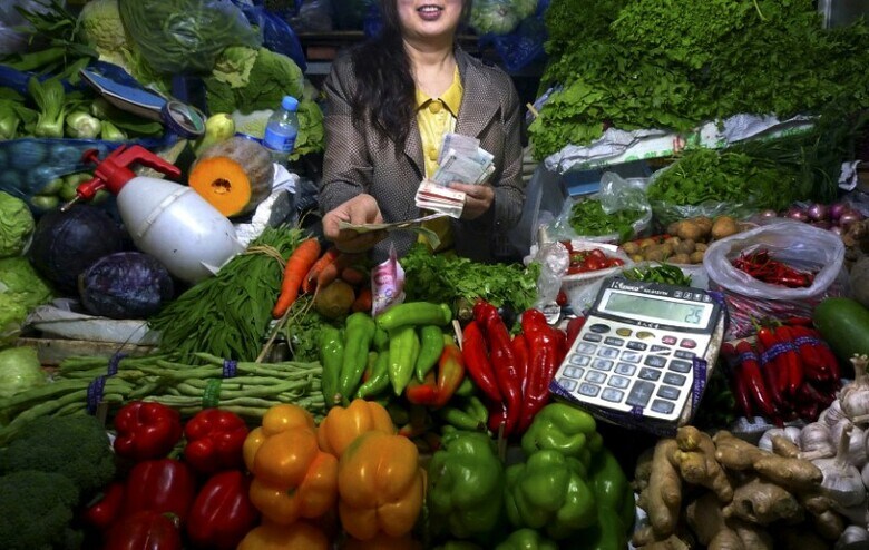 ６月２０日、中国の冷凍餃子メーカーは、売上げを伸ばす手軽な手段を発見しつつある。材料のうち、野菜の比率を上げて、肉を減らせばいいのだ。写真は２０１１年、北京の野菜市場で働く女性（２０１７年　ロイター/David Gray）