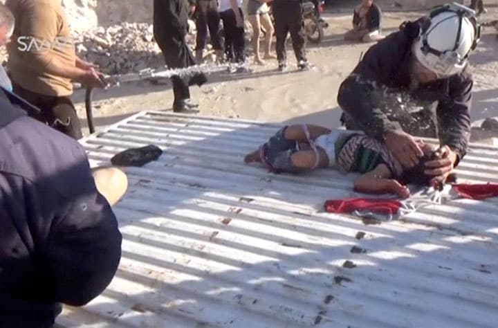 化学兵器によるとみられる空爆の後、毒を洗い流すために水をかけられる子供　Social Media Website/REUTERS