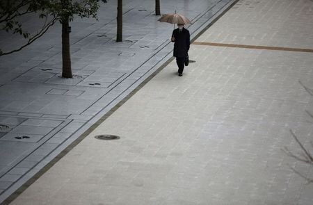 　ソフトバンクグループ<9984.T>の孫正義会長兼社長がツイッターで実施したアンケートによると、８０％以上が緊急事態宣言の発令を支持した。写真はマスクをして歩く男性。３月１０日、都内で撮影（２０１０年　ロイター　/Stoyan Nenov）