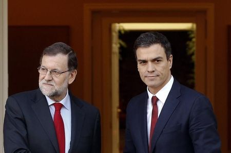 １２月２４日、週末に行われた総選挙で与党が過半数を失ったスペインで、再選挙を望んでいるのは国民の３分の１に満たず、３分の２が連立政権の樹立を望んでいることが世論調査の結果明らかになった。写真は１２月２３日、マドリードでの会談前に握手する国民党のラホイ党首と社会労働党のサンチェス党首（２０１５年　ロイター/Sergio Perez）