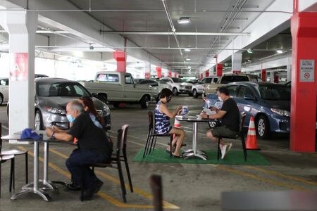 ８月３日、米カリフォルニア州のニューサム知事は定例会見で州内の新型コロナウイルス感染状況について、新規感染者や入院、集中治療室（ＩＣＵ）を利用する割合が全て低下傾向にあると説明した。写真は７月、カリフォルニア州グレンデールの駐車場に設けられたスペースで食事する人々（２０２０年　ロイター/Lucy Nicholson）