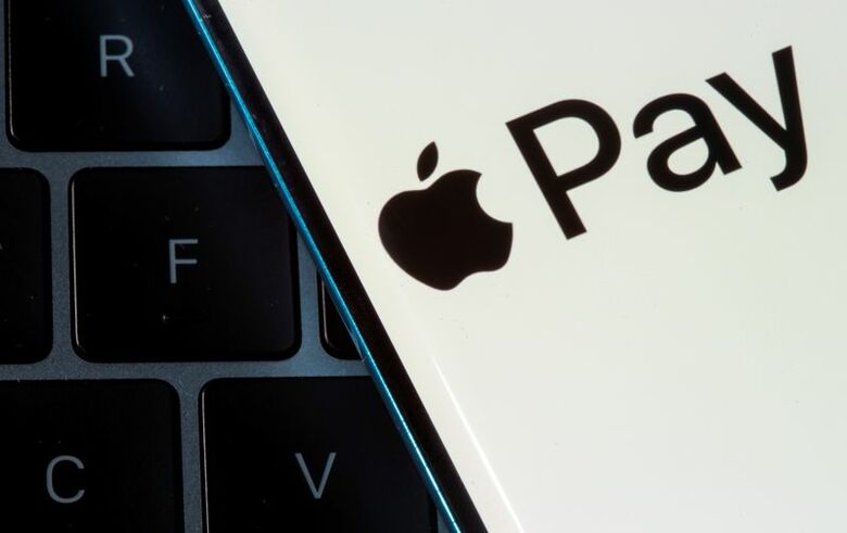 アップルペイのロゴを表示したスマートフォンとノートパソコンのイメージ。REUTERS/Dado Ruvic