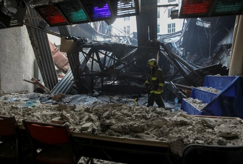 4月15日、ウクライナ南東部ドニプロで、ロシアによるドローン攻撃を受けた大学の建物で救助活動を行う救助隊員。REUTERS