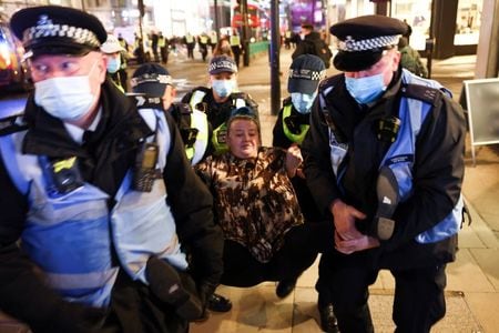英警察当局は、新型コロナウイルス対策の外出制限に違反したとして、ロンドン市民１０４人を逮捕したと発表した。写真は２０２０年１１月５日、ロンドン市内でロックダウンに反対する女性を拘束する警察官。（２０２０年　ロイター／Henry Nicholls）