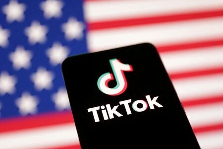 　４月９日、トランプ大統領は、中国系短編動画投稿アプリ「ＴｉｋＴｏｋ（ティックトック）」の米事業売却計画について、依然として検討中だと述べた。写真は、米国国旗と同アプリのロゴ。１月８日、ボスニア・ヘルツェゴビナのサラエボ市で撮影で撮影（２０２５年　ロイター/Dado Ruvic）