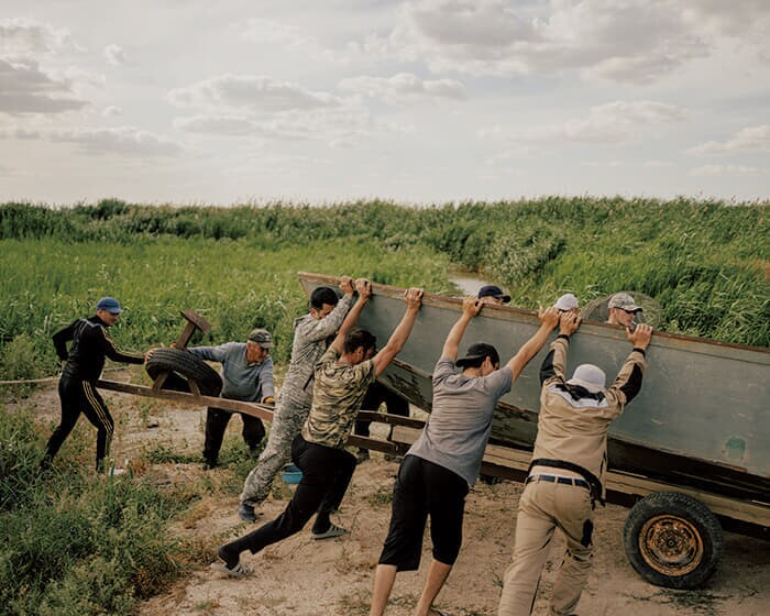ウラル河口の村ダンバで、身動きが取れなくなり放置された船を移動させる人々