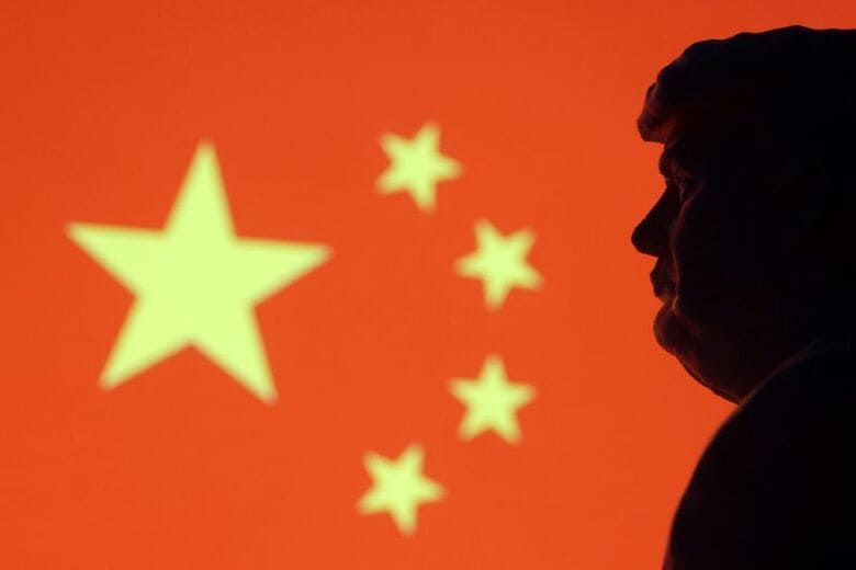 写真は中国国旗とトランプ米大統領の横顔のイメージ。2025年1月撮影。REUTERS/Dado Ruvic