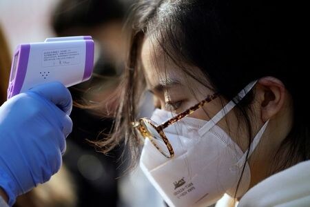　１月３１日、新型コロナウイルスによる肺炎の感染者が中国で９８００人を超えた。写真は上海のマスク工場で、体温チェックを受ける労働者（２０２０年　ロイター/Aly Song）