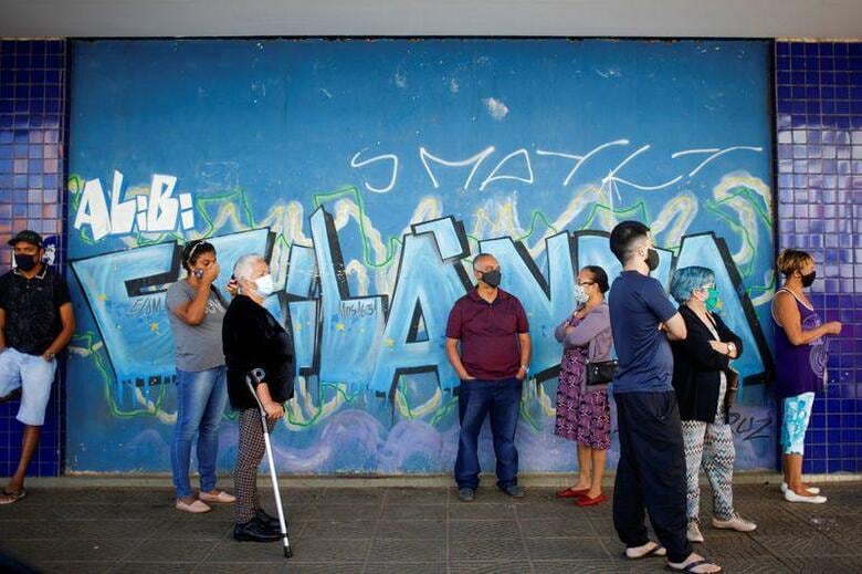 ブラジルの感染者数は170万人を超え、死者は7万人近い。米国を除けば世界最大の流行国だ。にもかかわらず、大統領から圧力を受けて、国内各地の市長や知事が隔離命令を緩めつつある。写真は銀行に並ぶ市民。7月7日、ブラジリアで撮影(2020年　ロイター/Adriano Machado)