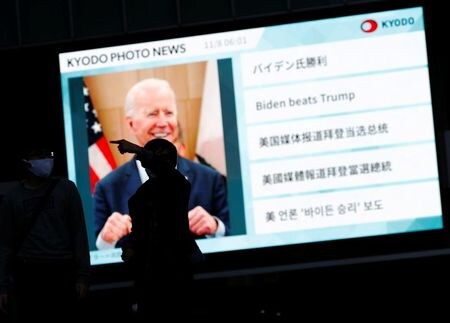 　１１月９日　米大統領選で勝利を確実にした民主党のバイデン前副大統領が、政権移行への準備を始めた。安倍晋三前首相がトランプ大統領と蜜月だった日本政府は、首脳間の新たな関係を構築するため、電話会談や訪米の早期実現に向けた調整を本格化させる構えだ。写真はバイデン氏の勝利を伝えるニュース画面。１１月８日、東京で撮影（２０２０年　ロイター/Issei Kato）