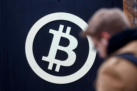 １２月１５日、仮想通貨ビットコインが最高値を更新。写真は１１月９日、ラトビア・リガで撮影したビットコインのロゴ（２０１７年　ロイター／Ints Kalnins）