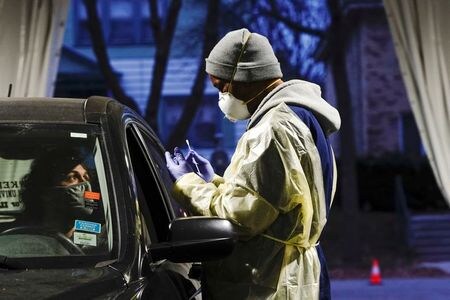 　ロイターの集計によると、米国で２３日、１日あたりの新型コロナウイルス新規感染者が８万４２１８人となり、過去最多を更新した。写真はドライブスルーで検査を行う医療関係者。２１日ミルウォーキーで撮影。（２０２０年　ロイター/Bing Guan）