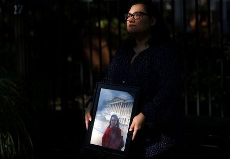 ９月２２日、ジバ・ムラートさんが最後に母親のグルシャン・アッバスさんに会ったのは２０１６年、場所は米首都ワシントン近郊のロナルド・レーガン・ワシントン・ナショナル空港だった。写真は母親の写真を手にするムラートさん。米バージニア州で６月撮影（２０２１年　ロイター/Leah Millis）