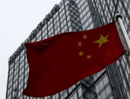 ９月１３日、中国財政省は、経営難に陥った不動産開発大手の中国恒大集団に対する会計監査を巡り、会計事務所プライスウォーターハウスクーパース（ＰｗＣ）の中国監査部門に対し、６カ月間の業務停止処分を科したと発表した。写真は２０１４年１月、北京にあるＰｗＣ支社の前に掲げられた中国国旗（２０２４年　ロイター／Kim Kyung-Hoon）