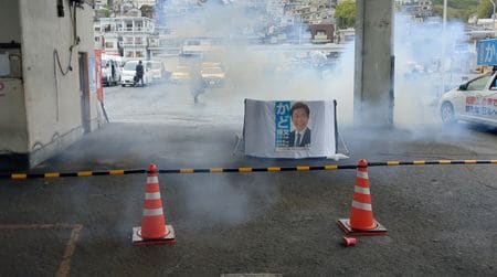 　４月１５日、松野博一官房長官は岸田文雄首相の和歌山市内での演説直前に爆発音がして容疑者の男が逮捕されたことを受け、警察庁に対し要人警護の徹底を図るよう指示したと述べた。不審物を投げ込んだ容疑者の動機や背景は「警察の捜査を待ちたい」とした。記者団に語った。 写真は爆発によって白煙が立ち込める和歌山市雑賀崎漁港の現場。ツイッターから（２０２３年　ロイター/Twitter @Ak2364N）