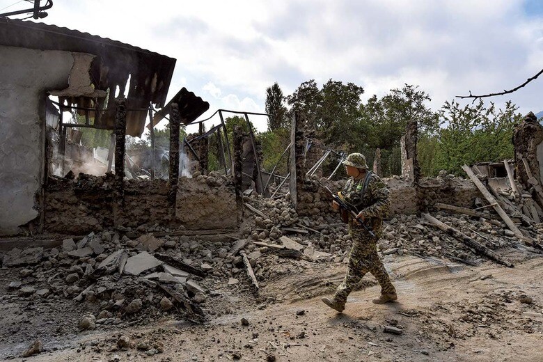 タジキスタンとの衝突で家屋が破壊された国境付近をパトロールするキルギス兵（9月21日）　AP/AFLO