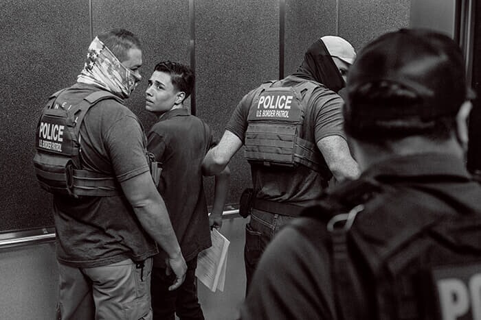 審理後に拘束され、エレベーターへと引きずられる移民。犯罪歴などはない"