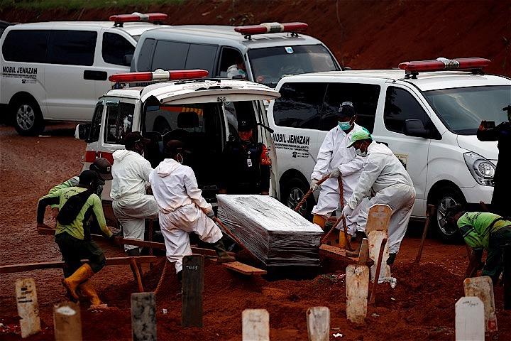 新型コロナウイルスによる死者が1万人を突破したインドネシア。24日もまた新たな棺が墓地に運び込まれた。REUTERS/Willy Kurniawan