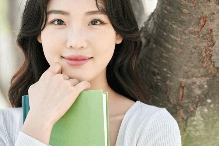 本を抱えて微笑む女性