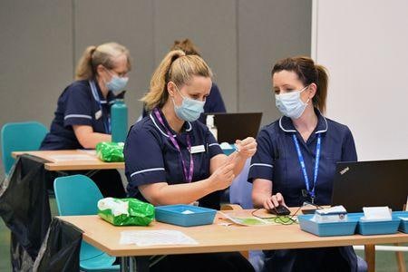 英政府は、医療従事者に対する新型コロナウイルスワクチン接種義務化の決定を撤回する方針を示した。すでに逼迫している医療に深刻な人員不足が生じる可能性があるとの警告を受けたもの。２０２１年１１月、サリー州の接種施設で代表撮影（２０２２年　ロイター/Dominic Lipinski）