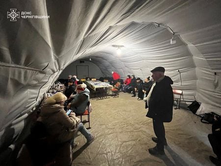 ウクライナ北部のチェルニヒウ州で２１日、ロシア軍によるエネルギー施設への攻撃により停電が発生し、数十万人に影響が出ている。チェルニヒウ州のヒーティングポイントで暖をとる人々、２１日の提供写真（２０２５年　ロイター/Press service of the State Emergency Service of Ukraine in Chernihiv region）