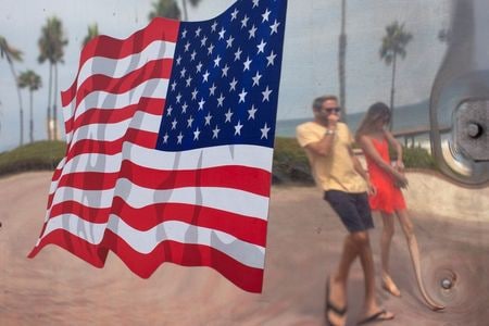 　８月４日、米疾病対策センター（ＣＤＣ）は４日、国内の新型コロナウイルス感染者が４万９７１６人増え、累計４６９万８８１８人になったと発表した。写真は米カリフォルニア州サンクレメンテでトラックに映る、ビーチに来た人々（２０２０年　ロイター/Mike Blake）