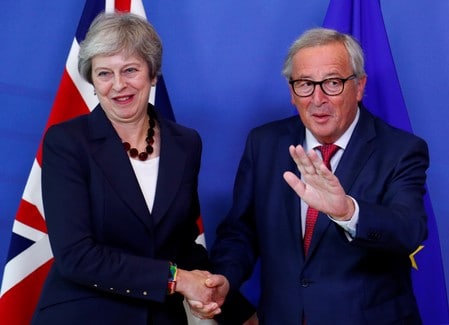 １０月１７日、英国のメイ首相は、ブリュッセルで欧州連合（ＥＵ）首脳会議に出席し、ＥＵ離脱交渉を巡る合意はなお可能との考えを示した。ブリュッセルで欧州委員会のユンケル委員長（右）と握手するメイ首相（２０１８年　ロイター/Francois Lenoir）