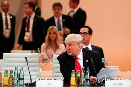 ７月１０日、トランプ米大統領はＧ２０首脳会議で長女イバンカ氏が大統領の席に座る場面があったことについて「極めて標準的」と擁護した。 写真はトランプ大統領（手前）、イバンカ氏（後）。８日、ハンブルクで撮影（２０１７年　ロイター/Markus Schreiber, Pool）