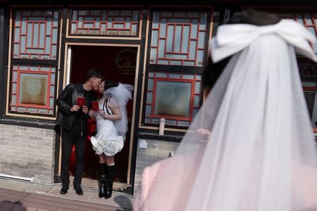 　１１月７日、 新婚旅行先を探していた銀行員のレン・シンシャオさんパートナーは、新疆ウイグル自治区に絶好の景勝地を見つけた。 写真は１０月、北京市内の寺院で結婚登記を済ませ、証明書を手にするカップル。REUTERS/Tingshu Wang