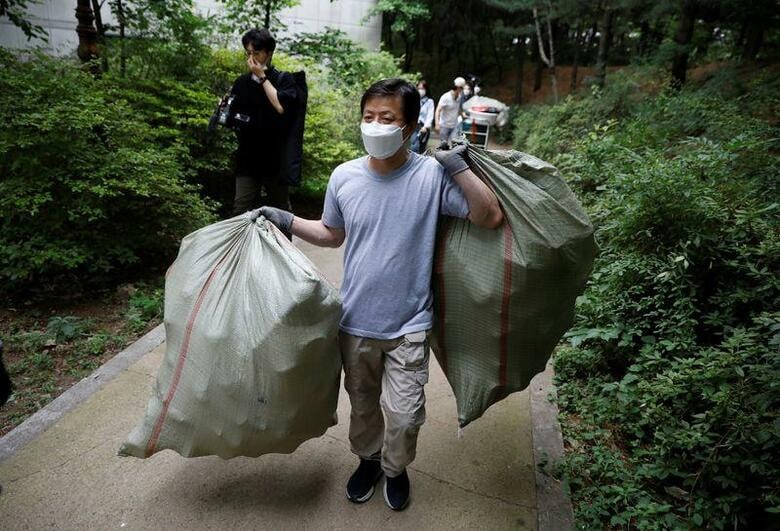 韓国の脱北者団体が１８日、コメなどを詰めたプラスチック製容器を海に流し、北朝鮮に送る計画の準備を進めた。写真は脱北者団体のリーダー、Park Jung-oh氏。北に送るコメを詰めるペットボトルを運ぶ。６月１８日、ソウルで撮影（２０２０年　ロイター/Kim Hong-Ji）