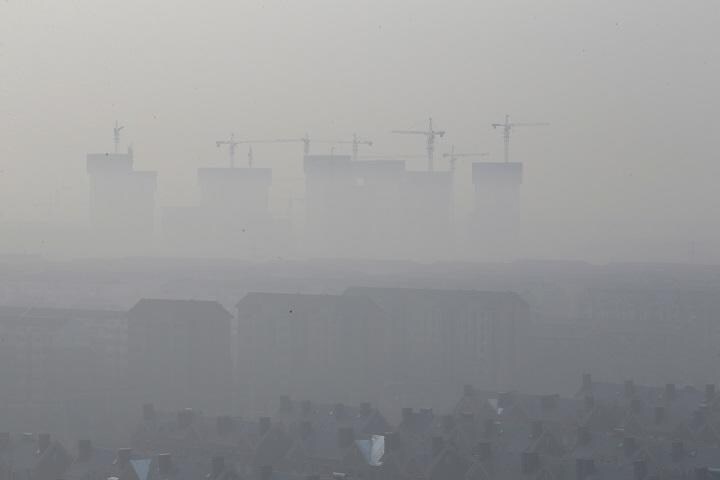 霧に霞む建設中の高層ビル群。手前は団地（2019年2月、中国・天津郊外）　Jason Lee-REUTERS