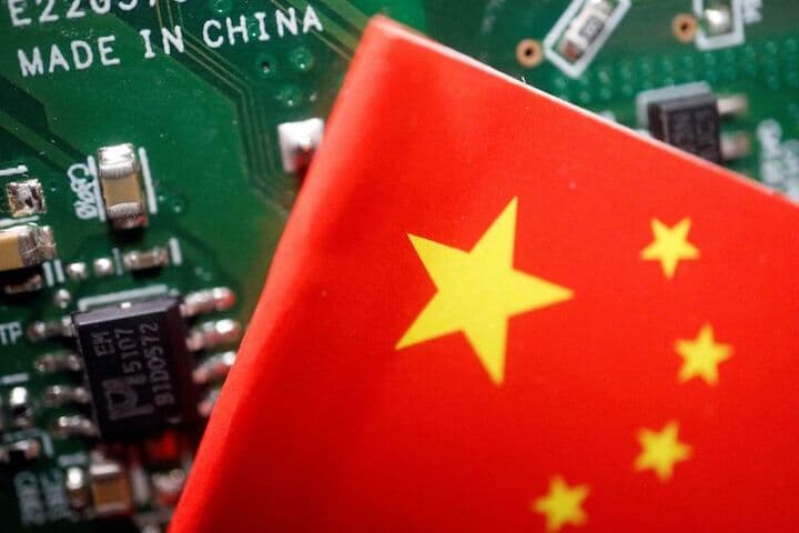 ３月５日、中国の李強首相は政府活動報告で、人工知能（ＡＩ）や宇宙など将来の競争力に不可欠な産業を育成すると表明した。写真は中国旗と半導体のイメージ。２０２３年２月撮影（２０２４年　ロイター/Florence Lo）