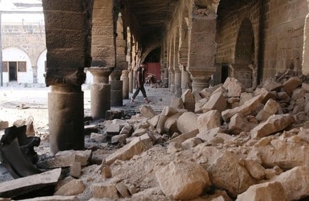 　６月１２日、シリア政権軍とイランが支援する民兵組織が、シリア南部ダルアーの反体制派が支配する地域への攻撃を強化している。写真は空爆により破壊されたモスクで瓦礫の間を歩く男性。ダルアーで９日撮影（２０１７年　ロイター／ALAA AL-FAQIR）