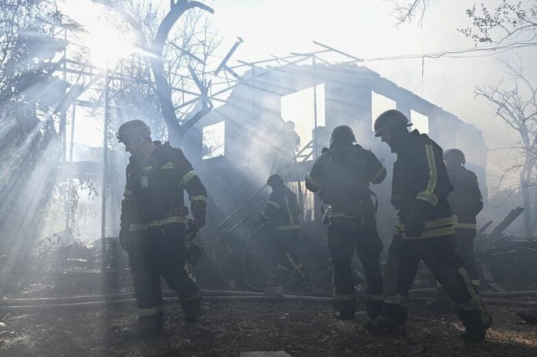 7月16日、ウクライナ南東部の都市ザポリージャで、ロシアの空爆を受けた住宅地で消火活動にあたる消防士たち。REUTERS