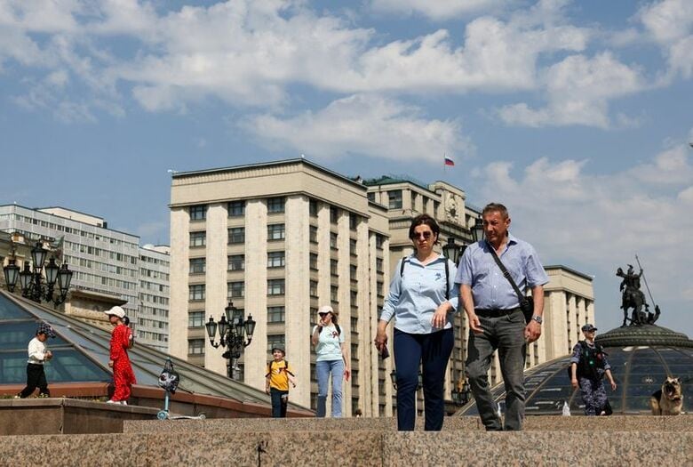 モスクワ中心部のロシア連邦議会下院近くの広場を歩く人々。5月撮影。 REUTERS/Anastasia Barashkova