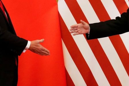 中国の外交担当トップの楊潔篪・共産党政治局員は７日、米国に対し、第１段階の通商合意の円滑な履行に向けた良好な環境を整えるため、協力強化を呼び掛けた。写真は、握手を交わすトランプ米大統領と習近平・中国国家主席。２０１７年１１月、北京で撮影（２０２０年　ロイター/Damir Sagolj/File Photo）