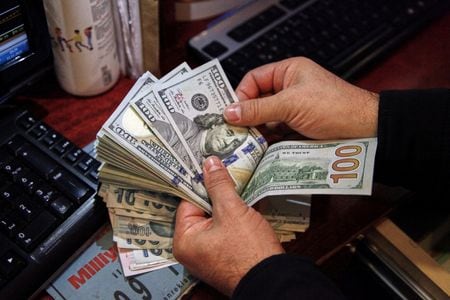 　１月３日、ニューヨーク外為市場では、米連邦準備理事会（ＦＲＢ）が利上げを実施する軌道から外れないとの観測から米国債利回りが上昇したことを背景に、ドルが主要通貨に対して上昇した。 写真はトルコ・アンカラの両替所でドル紙幣を数える人。２０２１年１１月撮影（２０２２年　ロイター/Cagla Gurdogan）