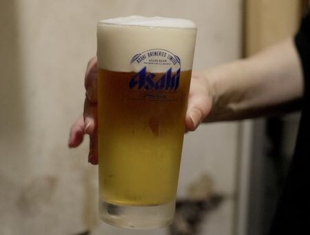 　アサヒグループホールディングスは１３日、傘下のアサヒビールの１０月売上高が概算で前年比９割超になったと発表した。写真はアサヒビールのグラスに注がれたビール。都内で１０月３日撮影（２０２５年　ロイター/Joseph Campbell）