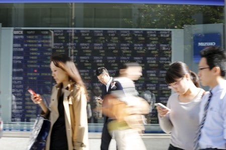 　１０月１７日、寄り付きの東京株式市場で、日経平均株価は前営業日比２５７円３５銭高の２万２８０６円５９銭となり、大幅続伸となった。その後も堅調に推移し、上げ幅を３００円超に拡大している。写真は都内の株価ボード前で２０１４年１０月撮影（２０１８年　ロイター／Yuya Shino）